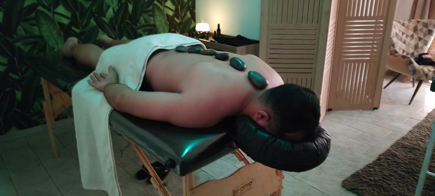 Cliente recebendo massagem com pedras quentes